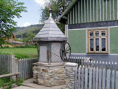 Typischer Brunnen nebst altem Bauernhaus in der Bukowina