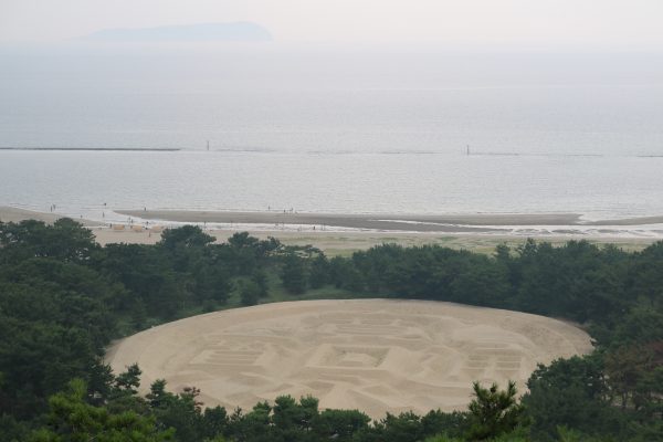 Die Zenigata-Sandskulptur. Am Horizont: Die Insel Ibukijima