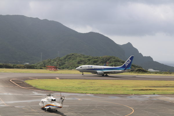 Hubschrauber und Linienflugmaschine auf dem Tarmac des Flughafens von Hachijojima