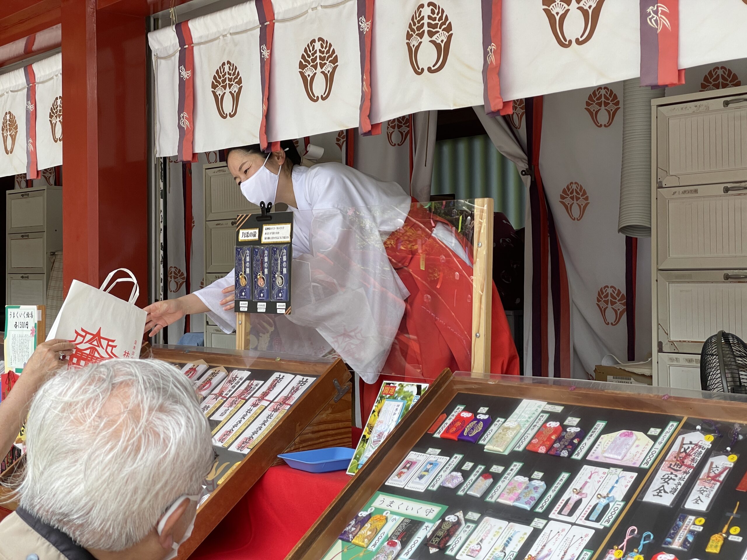 Miko (Schreinfrau) beim Amulettverkauf in einem Schrein