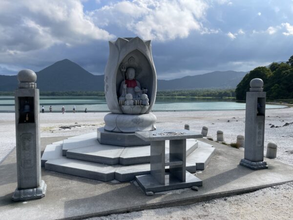 Buddhastatue und Glocke der Hoffnung am Seeufer